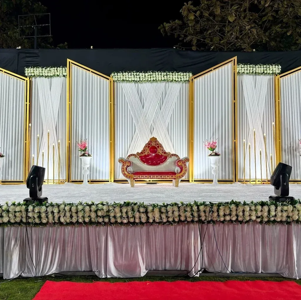 Night wedding stage with white drapes, gold frames and floral skirting
